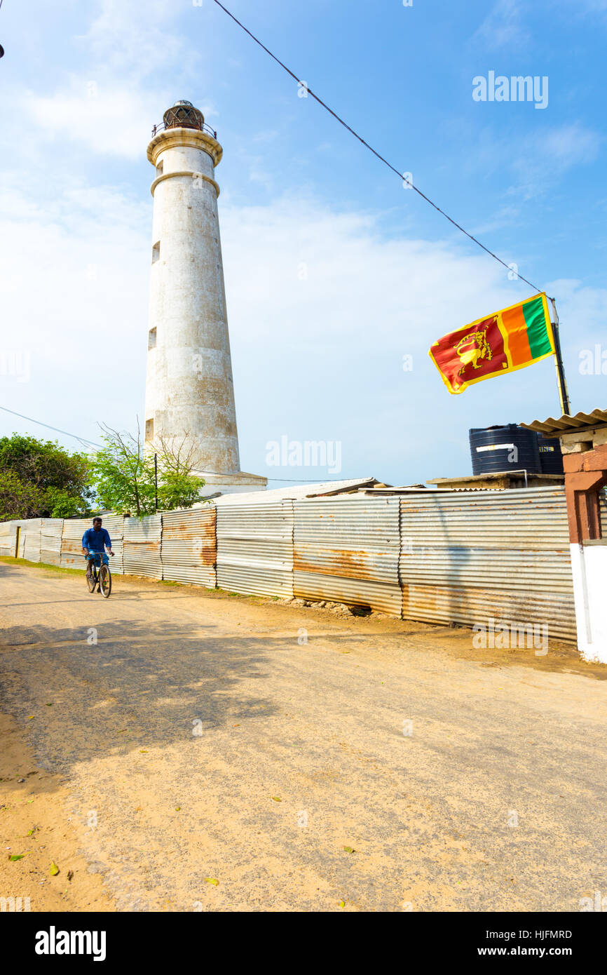 Ein Radfahrer fahren auf der Straße neben Point Pedro Lighthouse, ein Wahrzeichen jetzt besetzt durch das Militär an der Nordküste, Jaffna Stockfoto