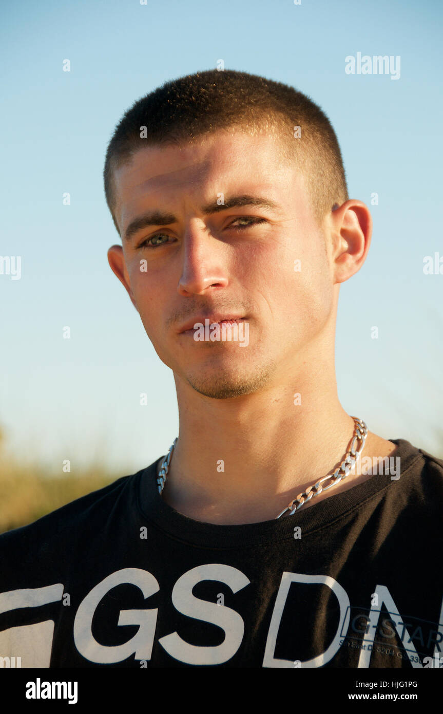 Junger Mann mit Kette Rundhals-Ausschnitt in der Abendsonne Stockfotografie  - Alamy