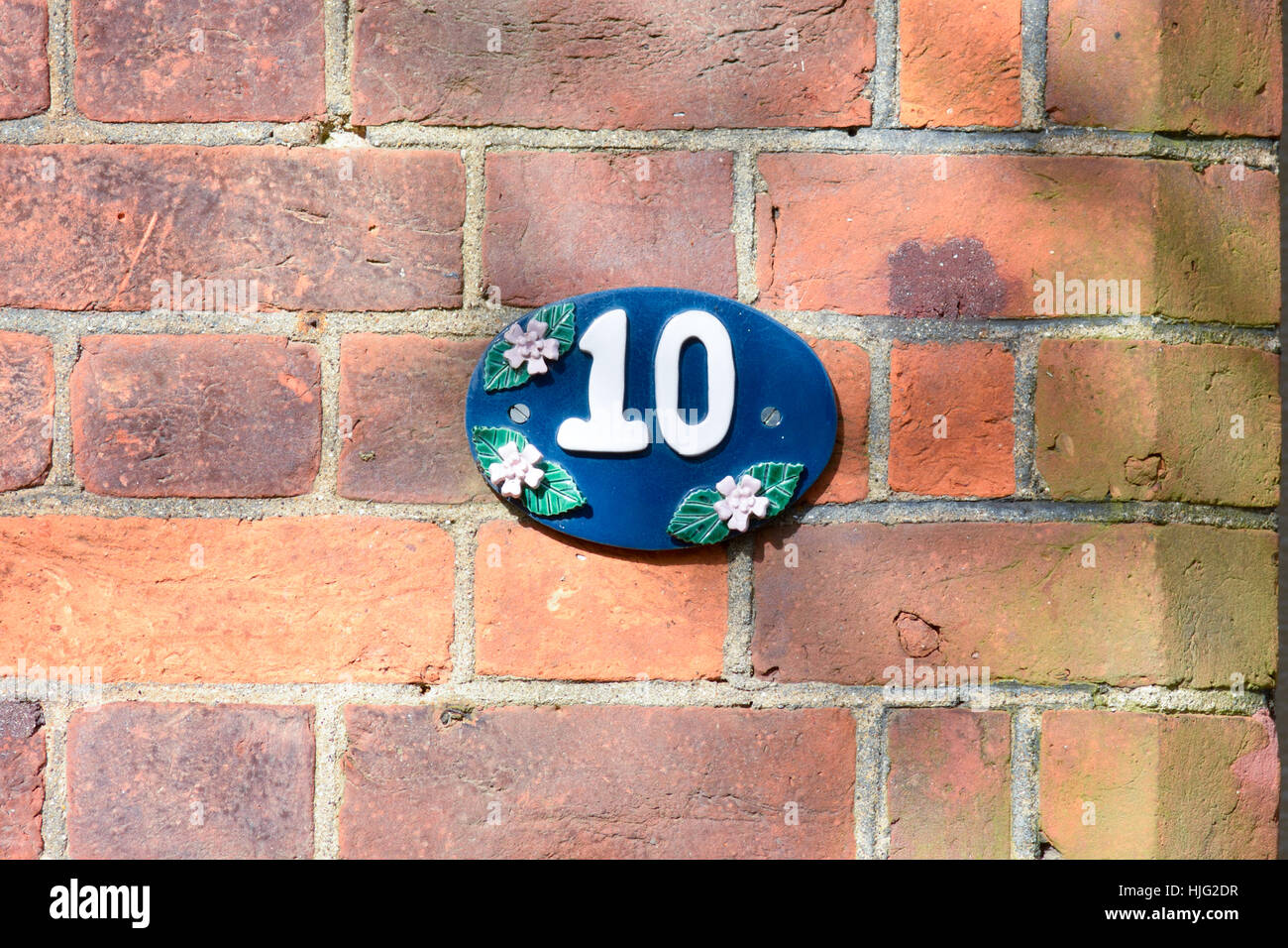 Hausnummer 10 Zeichen befestigt an der Wand Stockfoto