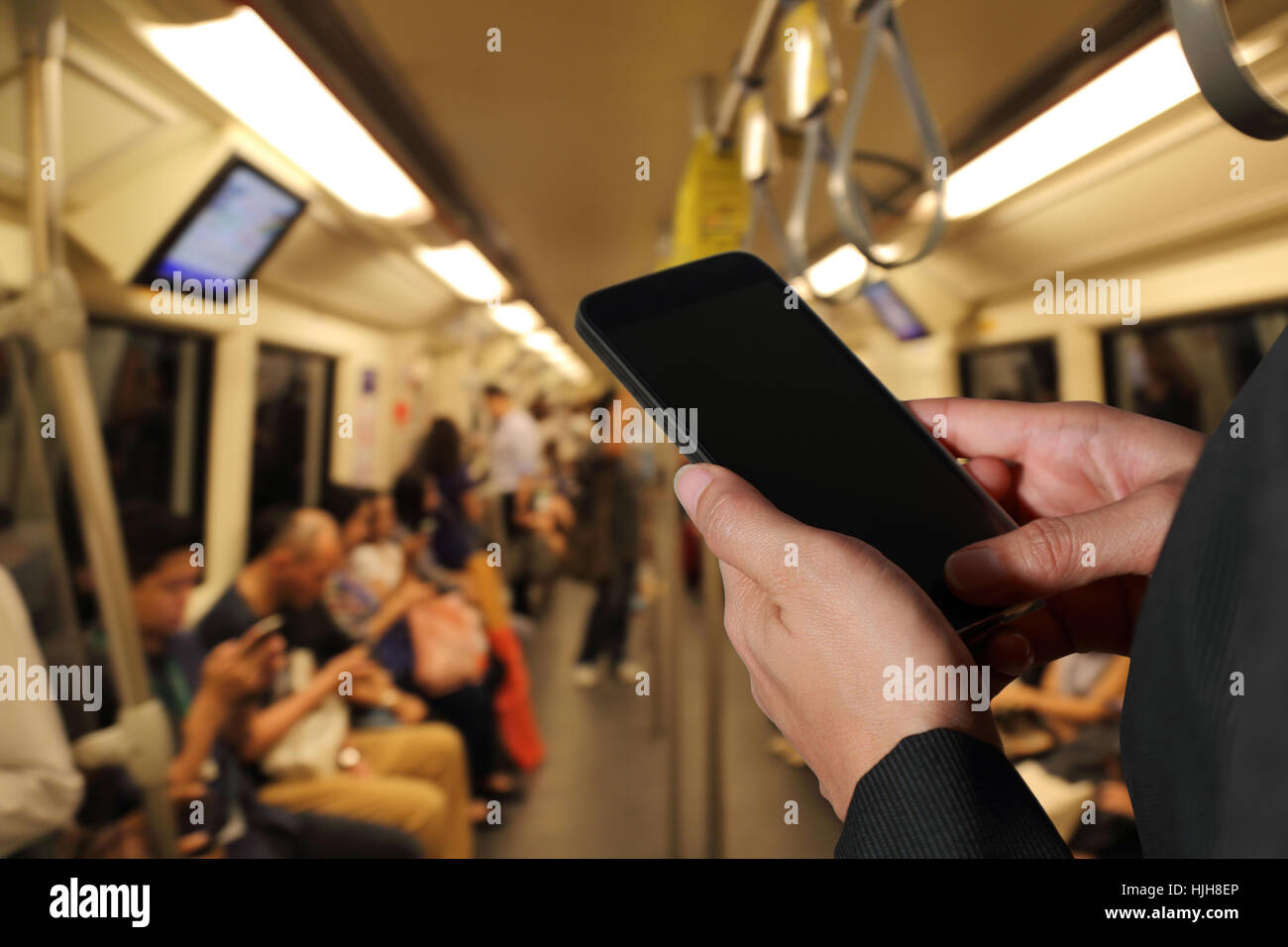 Frau Hand halten Smartphone, Handy auf unscharfe abstrakte Stadt u-Bahn Hintergrund als tägliche Routine Konzept. Stockfoto