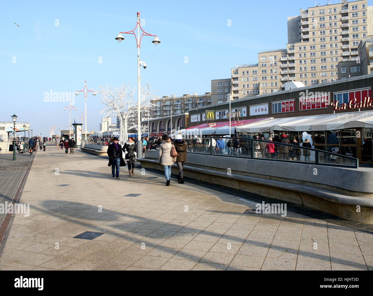 Touristen gehen auf dem Boulevard von Scheveningen. Nordsee Badeort Scheveningen - Den Haag (The Hague), Niederlande Stockfoto