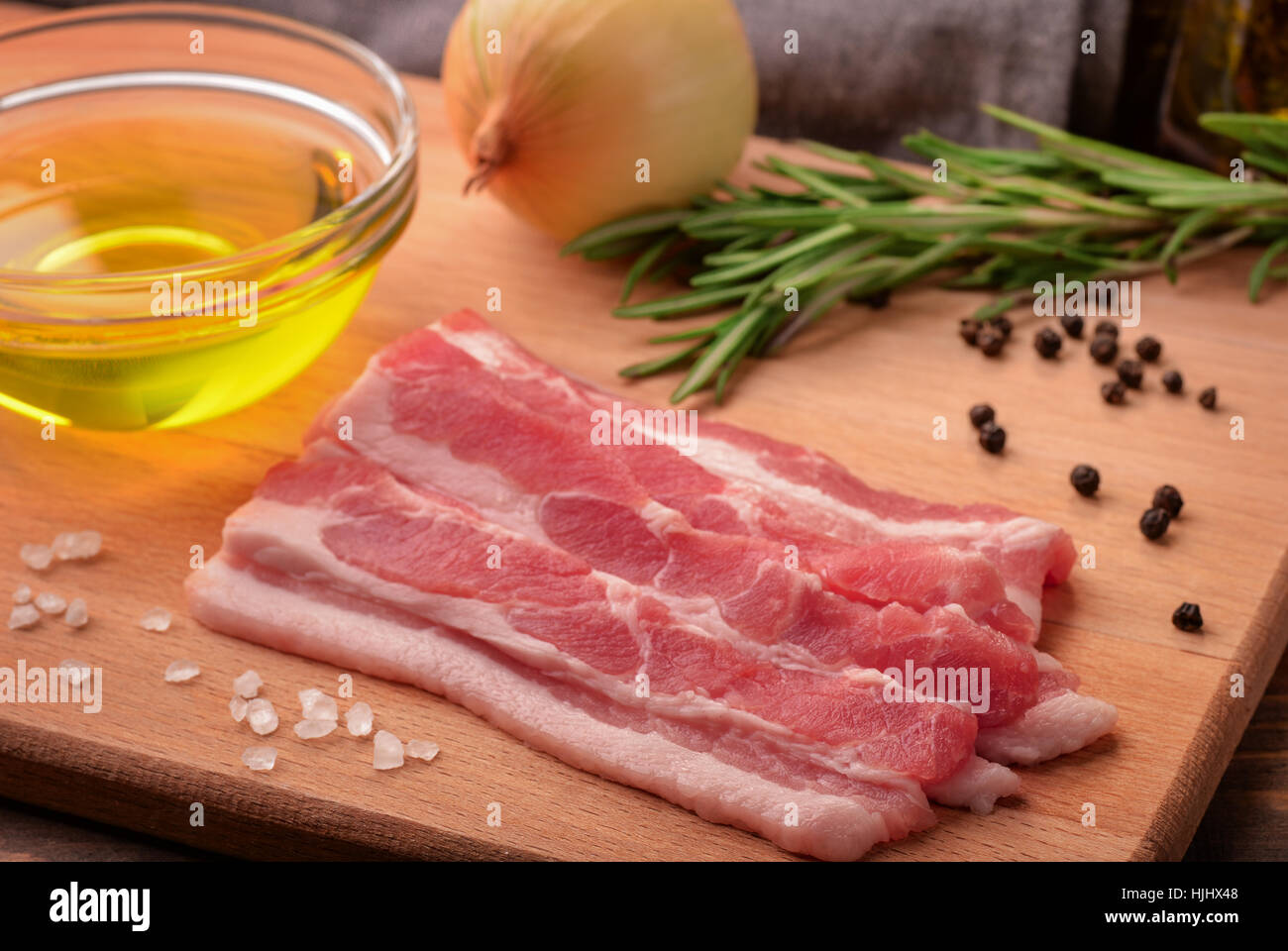 Stillleben mit in Scheiben geschnittenen rohen Speck, Olivenöl, Gewürze und Kräuter Stockfoto
