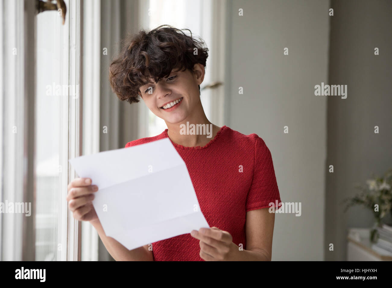 Porträt der lächelnde junge Frau liest einen Brief Stockfoto