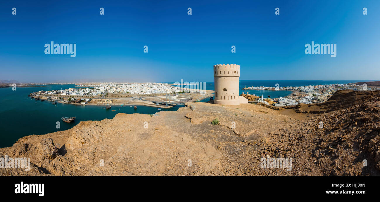 Oman, Ash Sharqiyah, Ad Daffah, Blick zum Seehafen Sur und Blue Lagoon mit Wachturm im Vordergrund Stockfoto