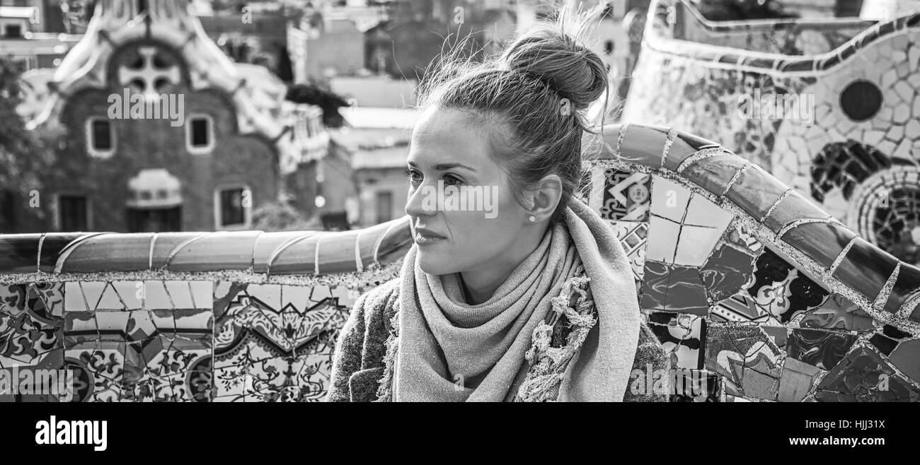 Barcelona-Handschrift. elegante Frau im Mantel in Barcelona, Spanien, Blick in die Ferne auf Bank sitzend Stockfoto