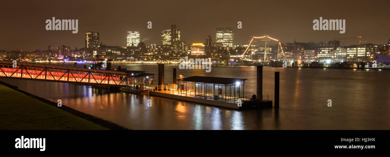 Deutschland, Hamburg, Blick zum beleuchteten Stadt an Elbe und Fähre Dock im Vordergrund Stockfoto