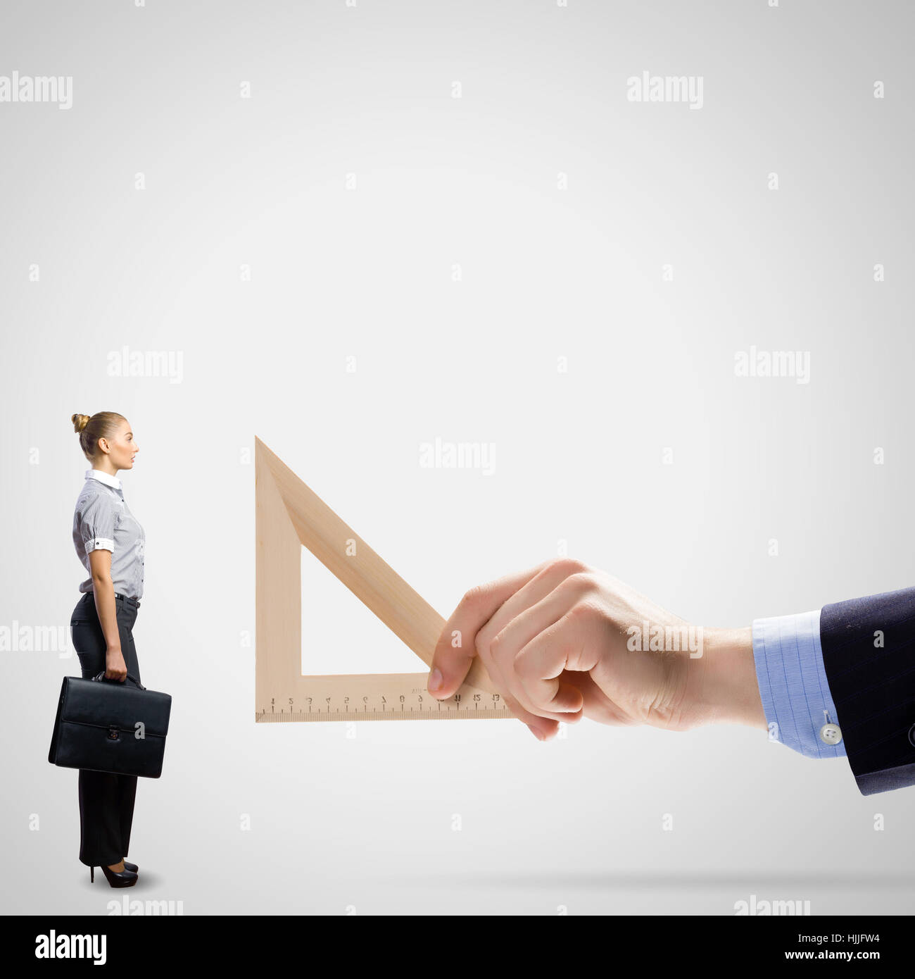 Geschäftsmann, die Messung der Miniatur des Business-Dame mit Lineal Stockfoto