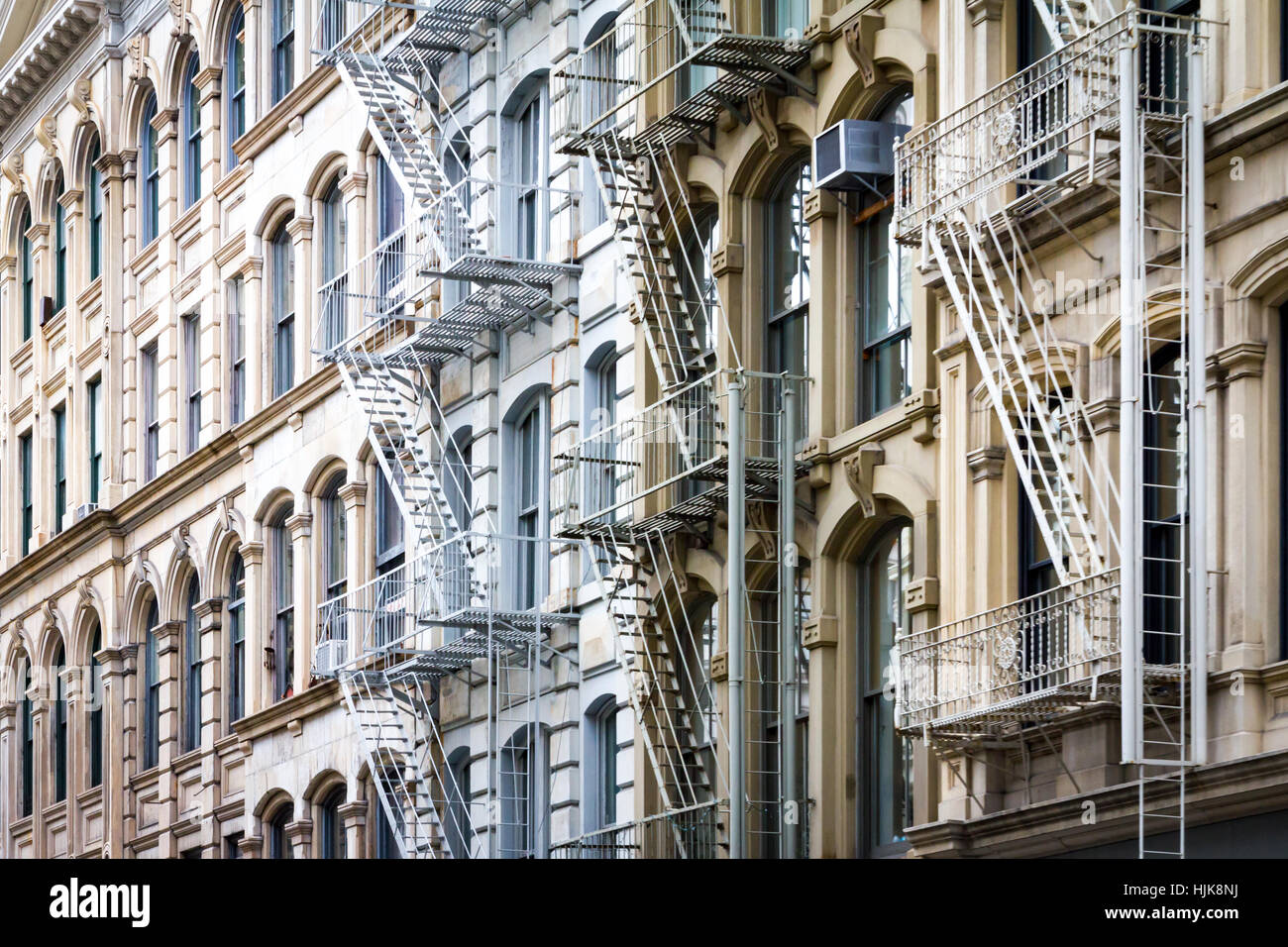 Historische Gebäude-Architektur-Hintergrund mit alten Fenstern und Feuerleitern in SoHo Manhattan, New York City NYC Stockfoto
