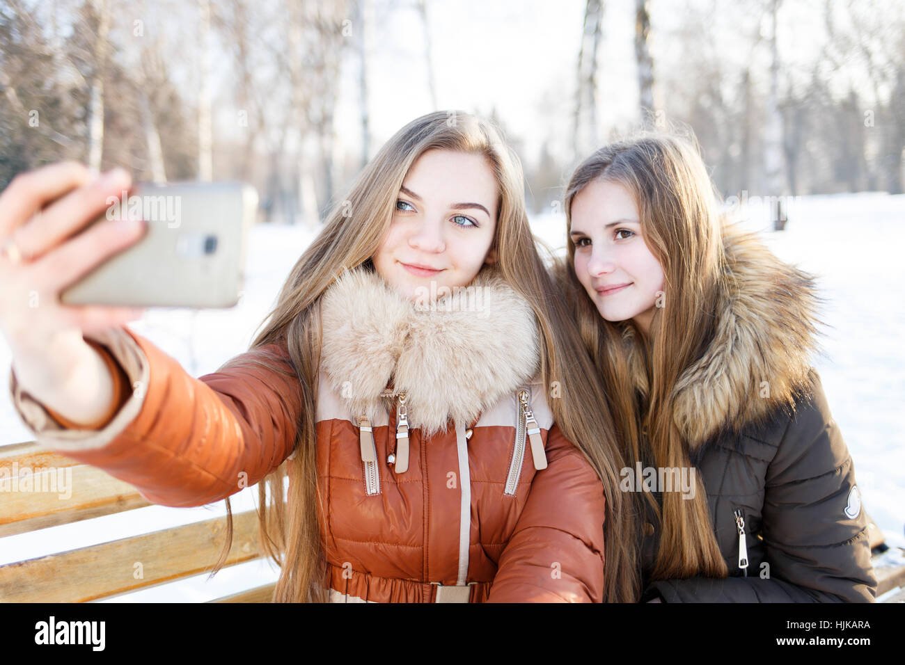 Zwei lächelnde Mädchen machen Selfie in Winter park Stockfoto