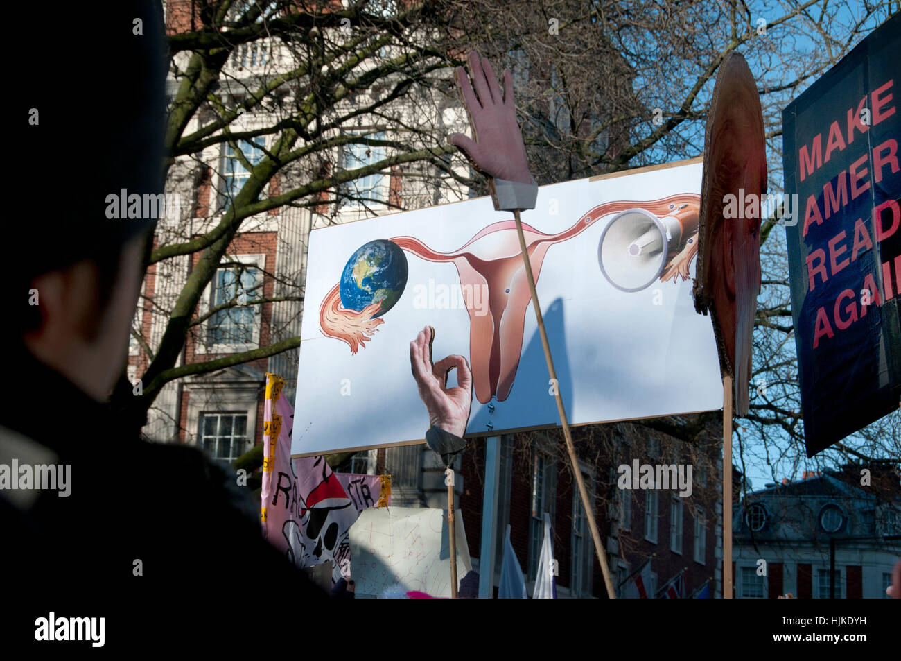 Frauen Anti-Trump März, London. Trumps Kopf auf einem Stick, seine Hände und ein Plakat zeigt eine Frau reproduktive Organe Stockfoto