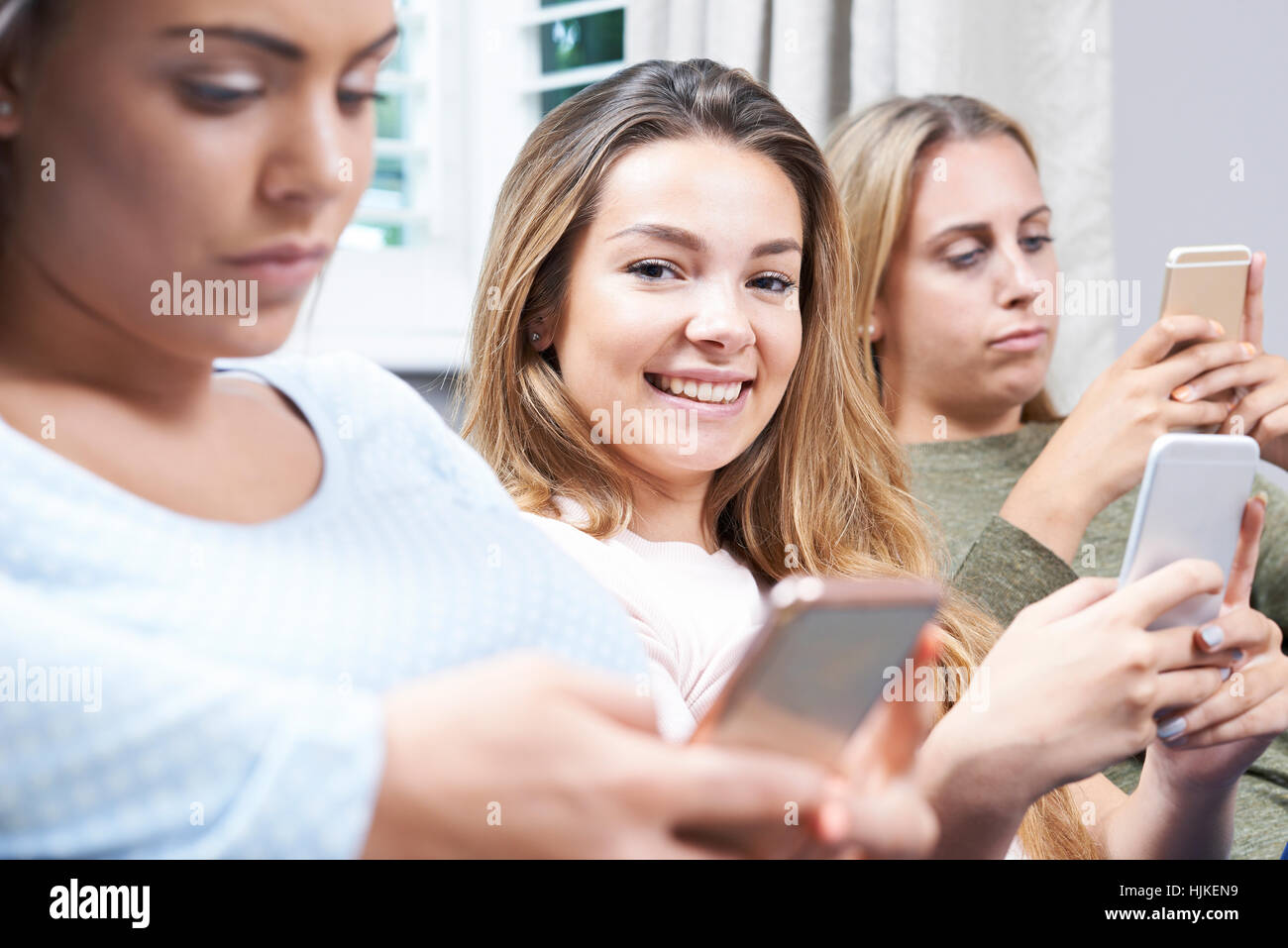 Gruppe von Mädchen im Teenageralter mit Handys zu Hause Stockfoto