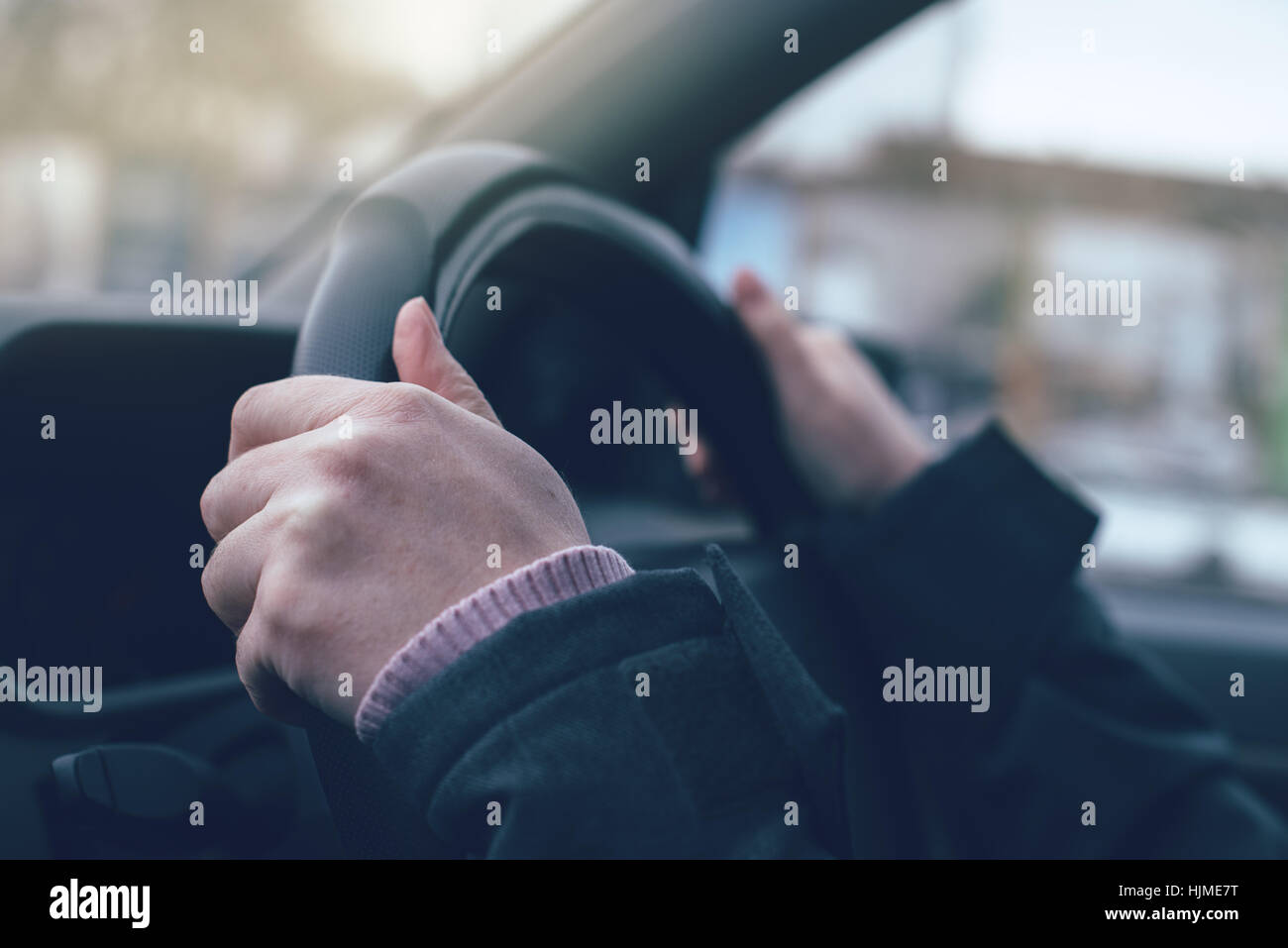 Weibliche Hände greifen das Lenkrad eines Autos hautnah mit selektiven Fokus Stockfoto