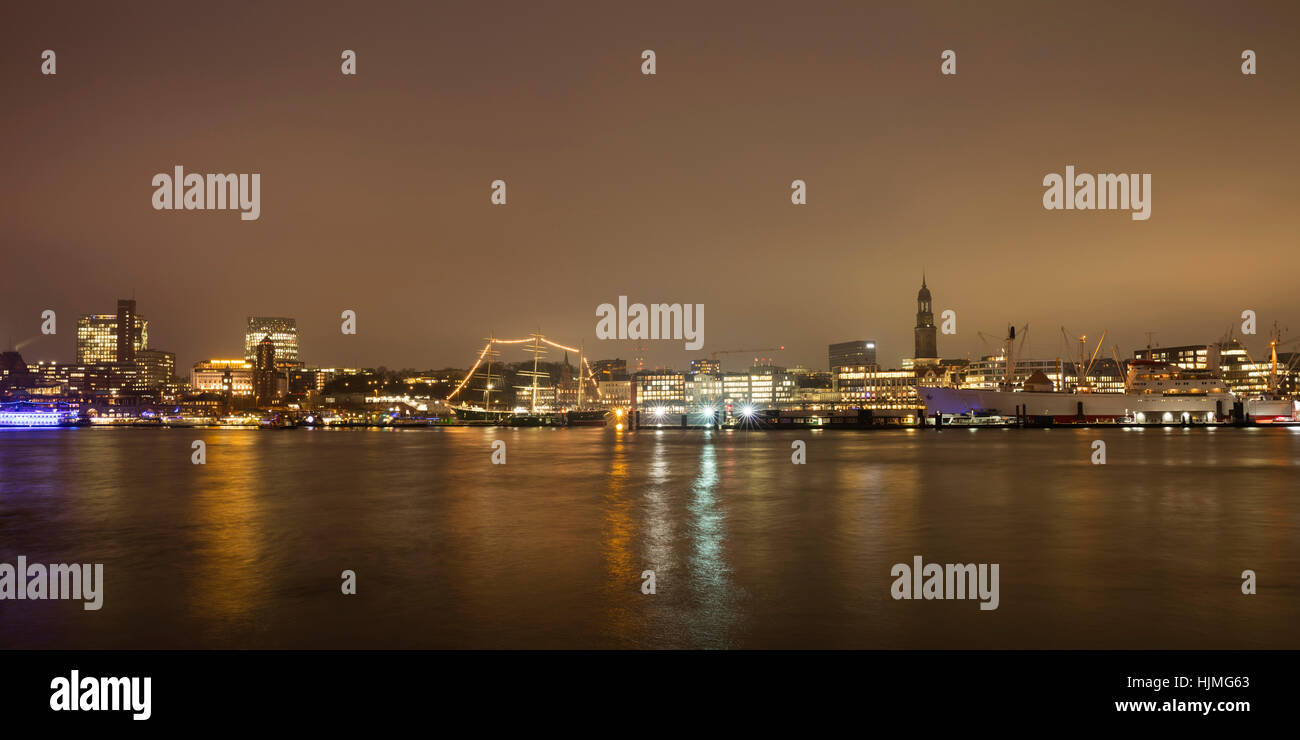 Deutschland, Hamburg, Blick auf die beleuchtete Stadt mit Elbe Fluss im Vordergrund Stockfoto