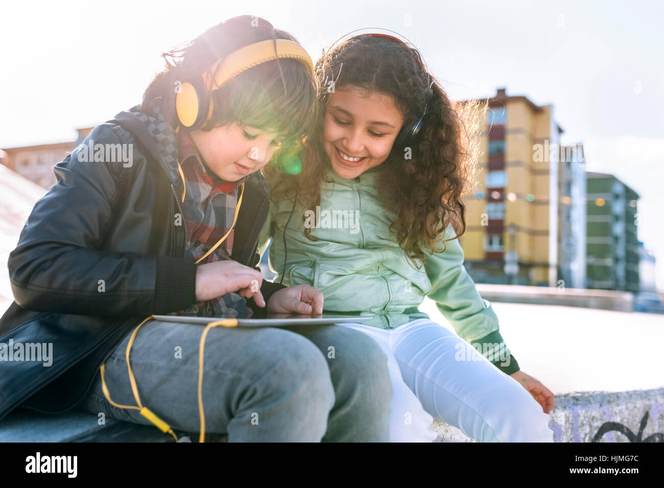 Zwei Kinder mit Kopfhörer und tablet Stockfoto