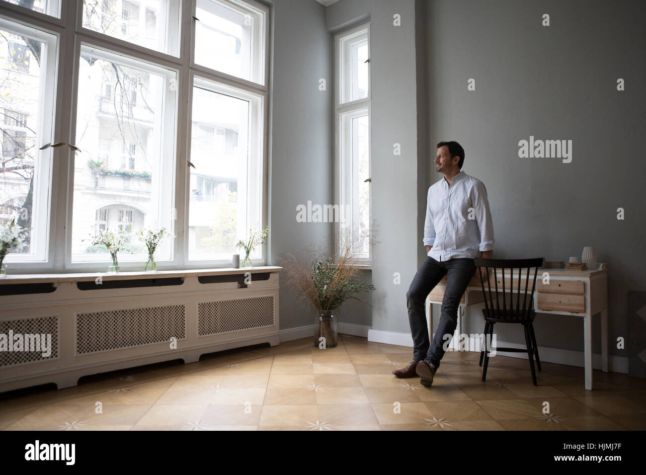 Mann auf der Suche durch Fenster zu Hause Stockfoto
