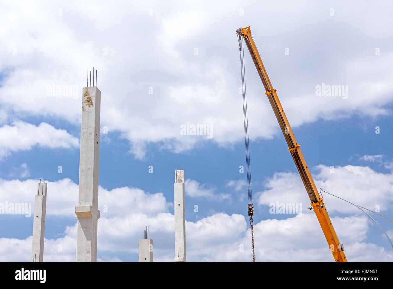 Kranarm ist zur Montage Betonsäulen auf neue Gebäude in Betrieb. Stockfoto