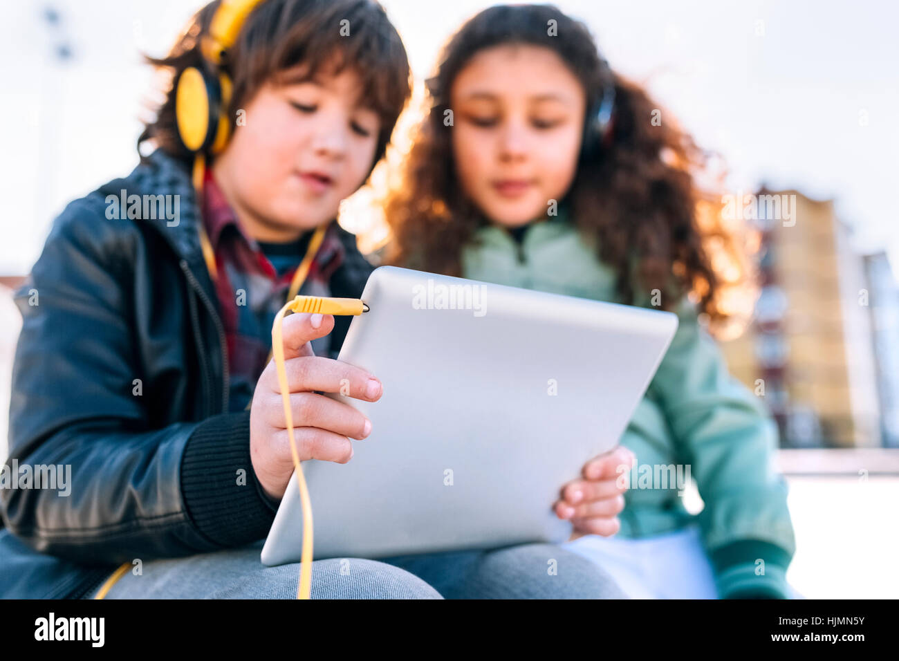 Zwei Kinder hören Musik mit Kopfhörern und tablet Stockfoto
