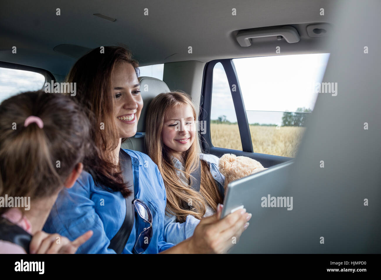 Mutter und Töchter Road trip sitzen im Auto Blick auf digital-Tablette Stockfoto