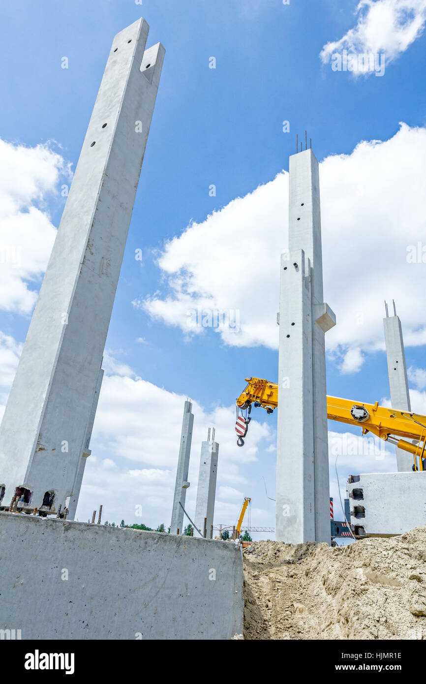 Kranarm ist bereit für den Betrieb, Montage Betonsäulen auf neue Gebäude. Stockfoto