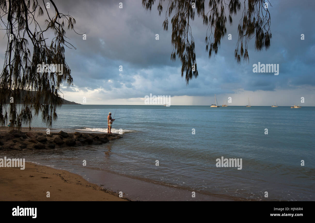 Menschen, die Angeln bei Sonnenuntergang am Strand von Horseshoe Bay, Magnetic Island-Queensland-Australien Stockfoto