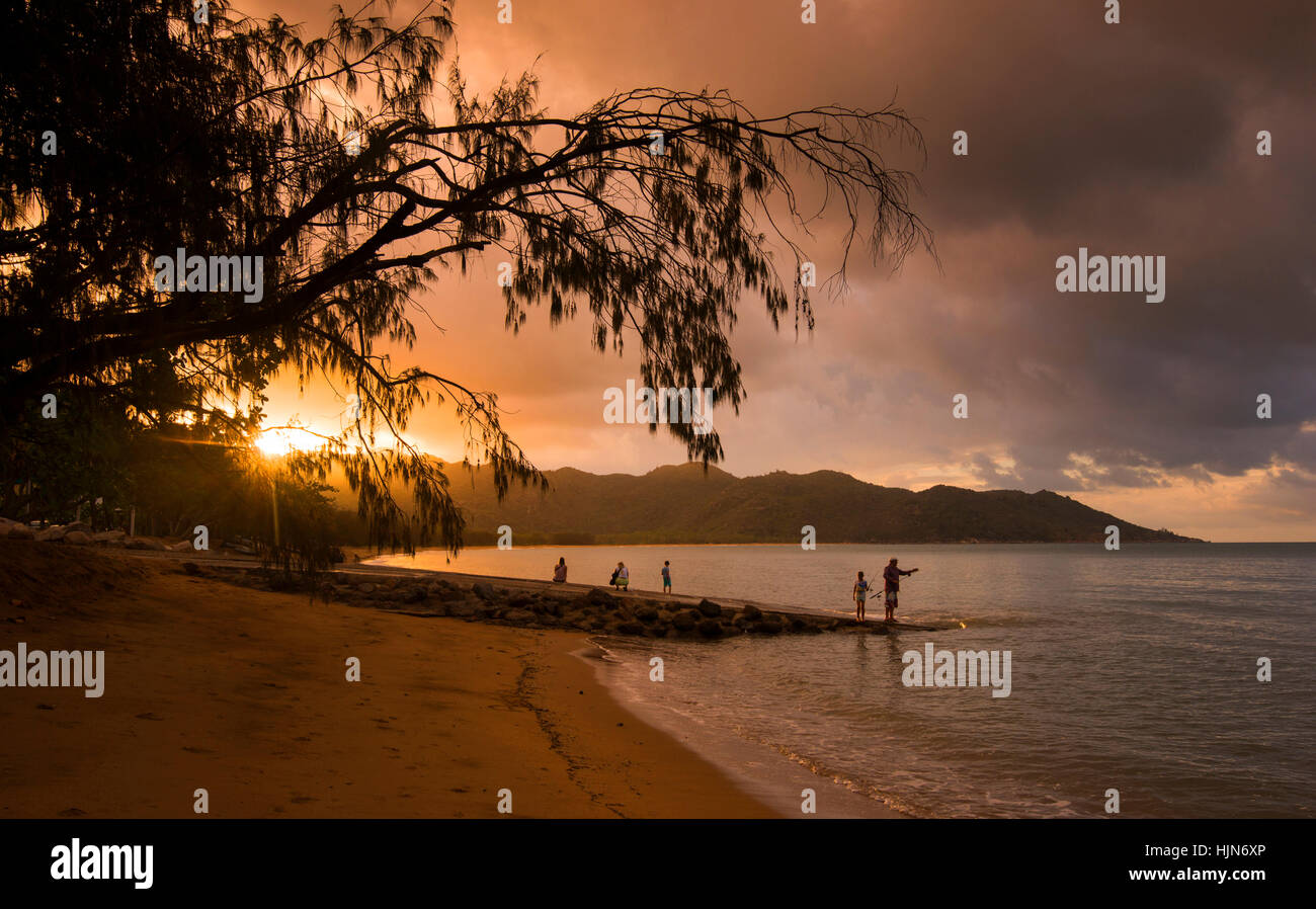 Menschen, die Angeln bei Sonnenuntergang am Strand von Horseshoe Bay, Magnetic Island-Queensland-Australien Stockfoto