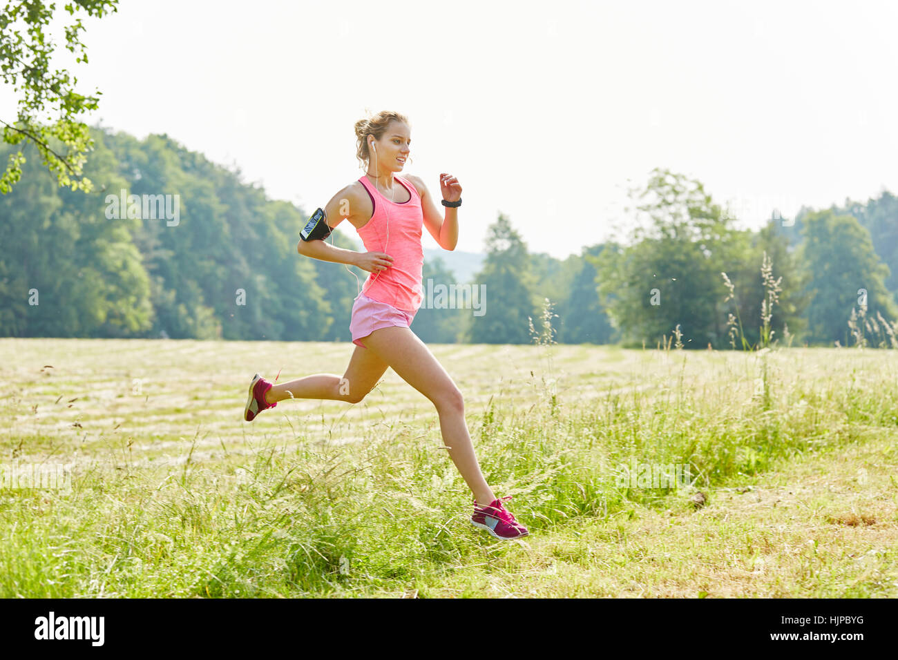 Junge Frau mit Smartwatch als Jogger laufen schnell im park Stockfoto