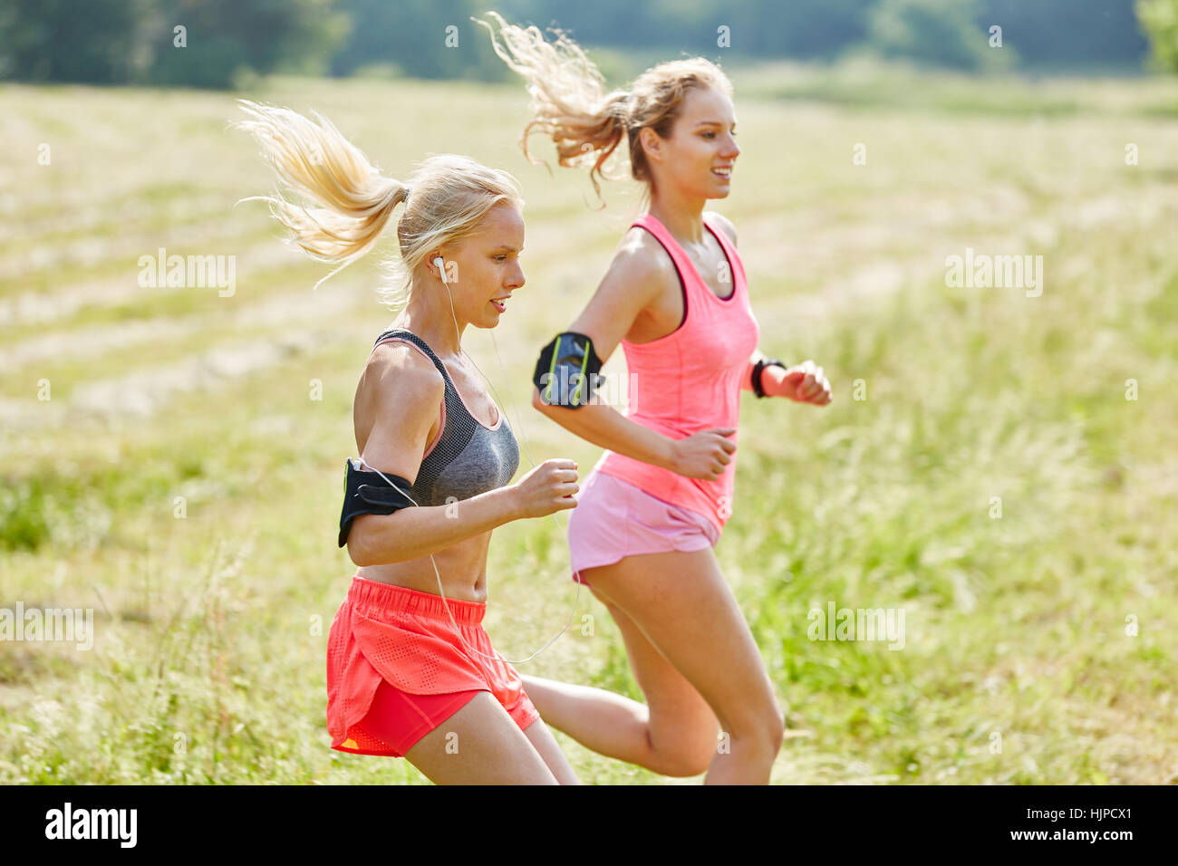 Zwei junge Frauen, die zusammen als Freunde laufen in der Natur Stockfoto