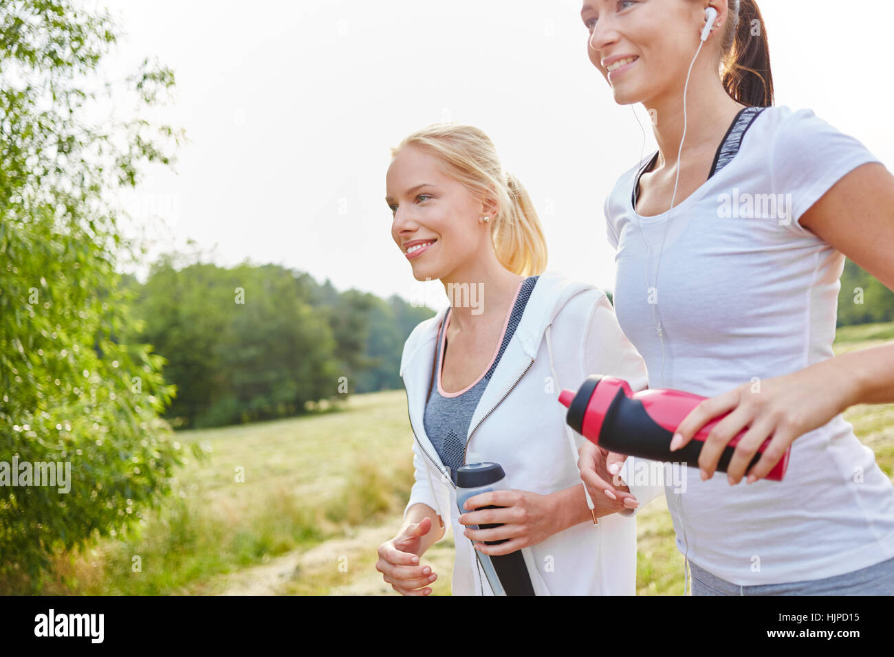 Zwei junge Frauen, die Joggen im Park zusammen im Sommer Stockfoto