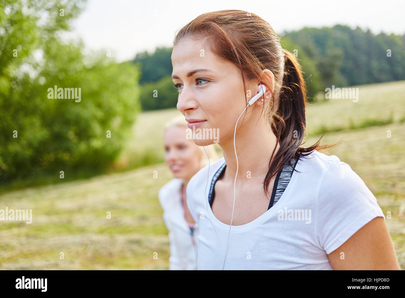 Junge Sportler Frau Musikhören mit MP3-Player in der Natur Stockfoto