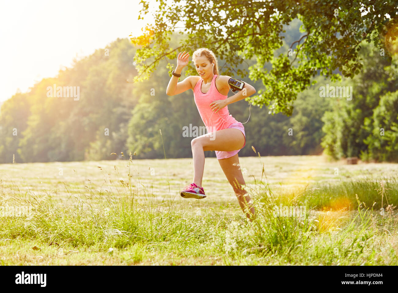 Frau rennt mit Smartwatch und MP3-Player im Sommer Stockfoto