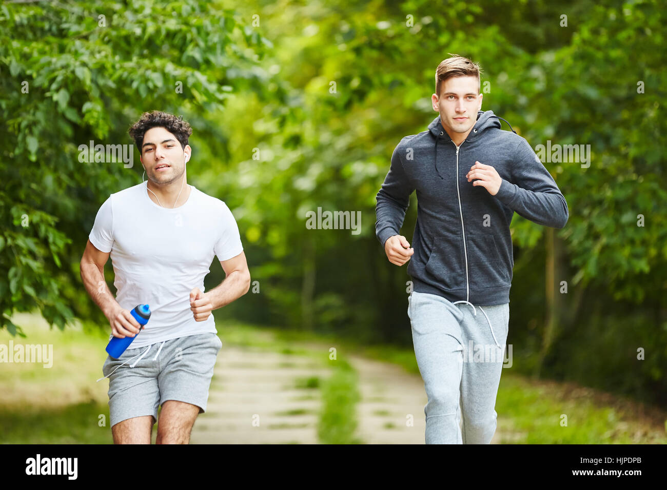 Zwei junge Männer, die laufen im park Stockfoto
