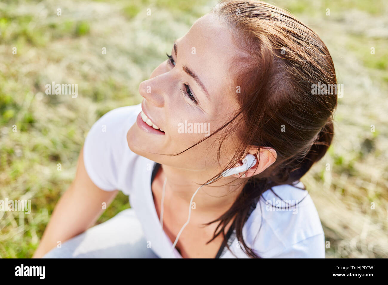 Junge Frau hört MP3-Player vor ihrem jogging Kurs Stockfoto