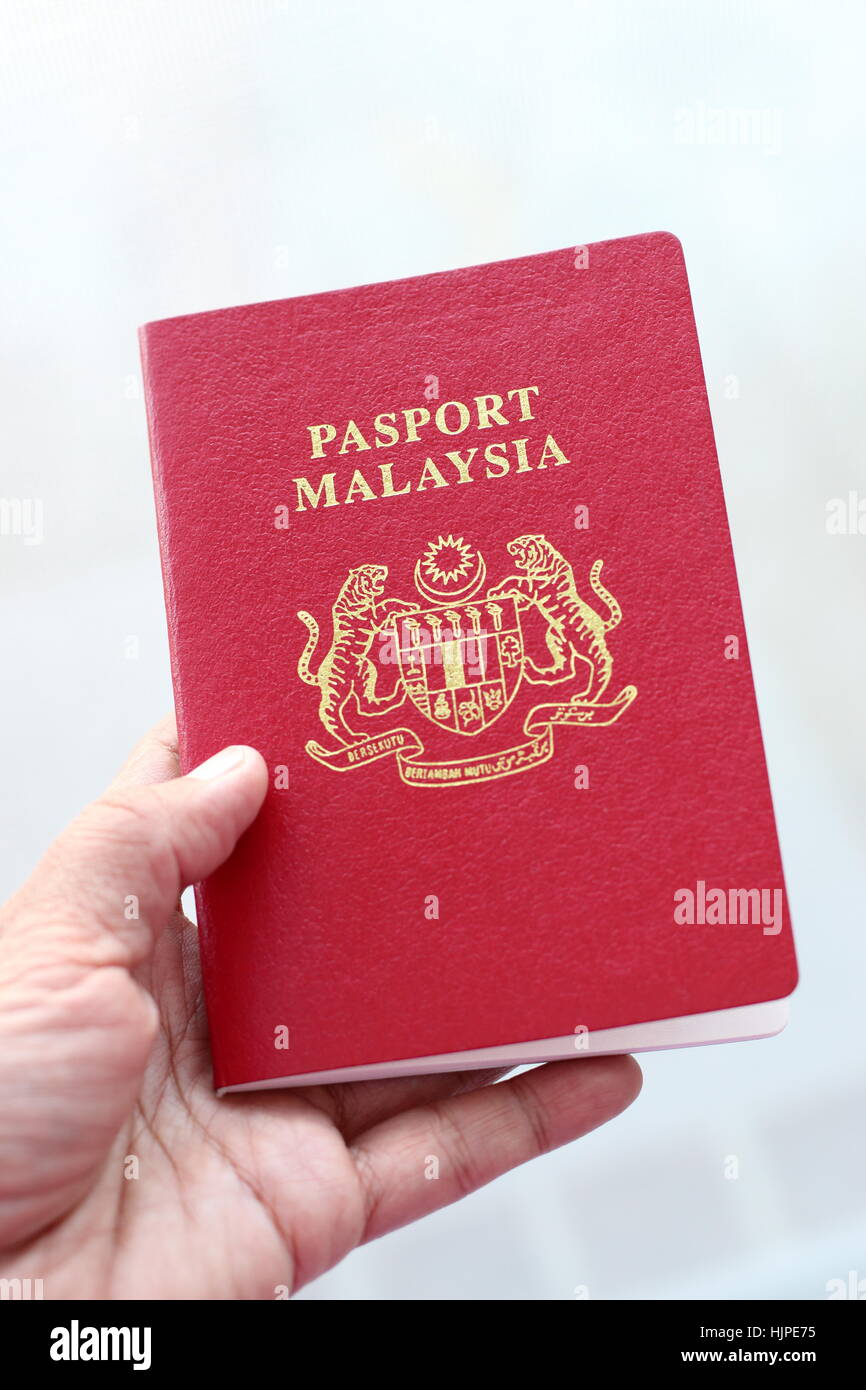 Hand, die malaysische Pass auf weißen Hintergrund isoliert Stockfoto