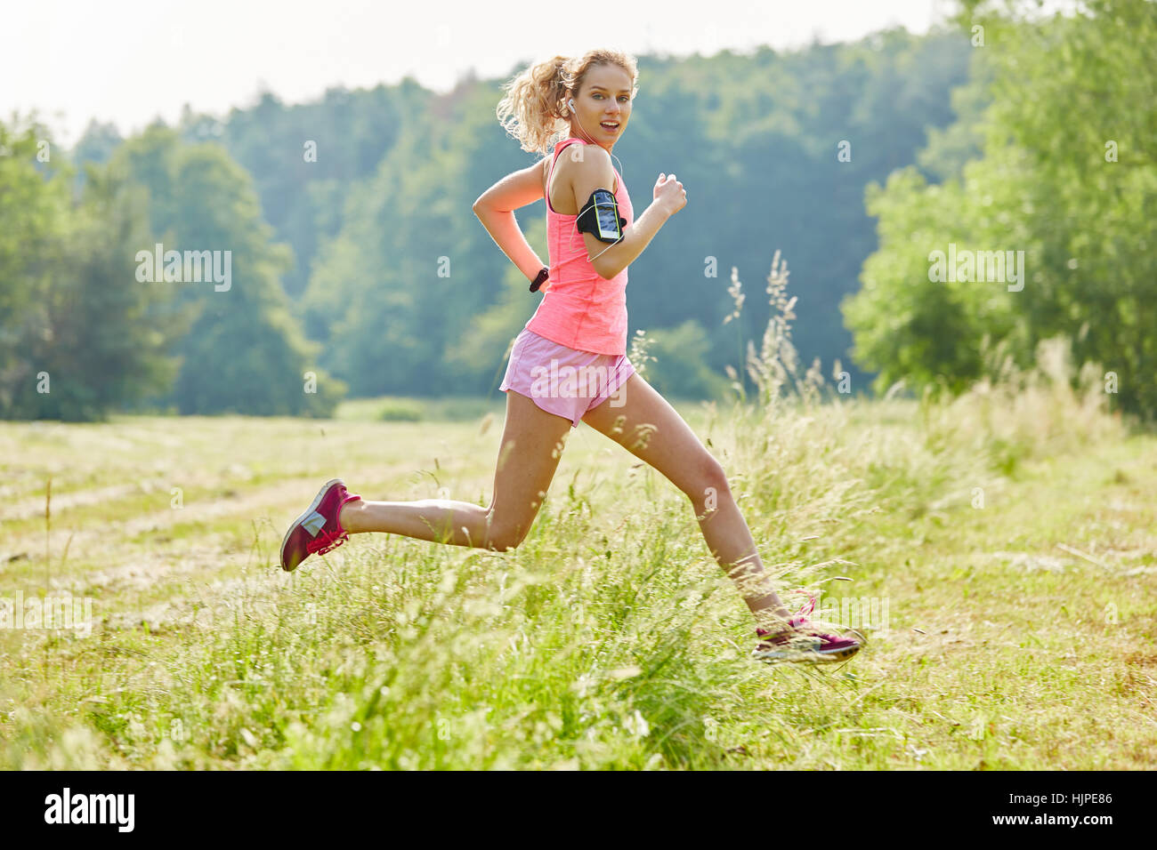 Junge Frau joggin mit Smartwatch in der Natur beim Fitness-training Stockfoto