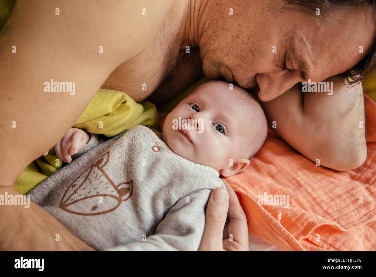 Vater im Bett mit seinem Neugeborenen Baby kuscheln Stockfoto