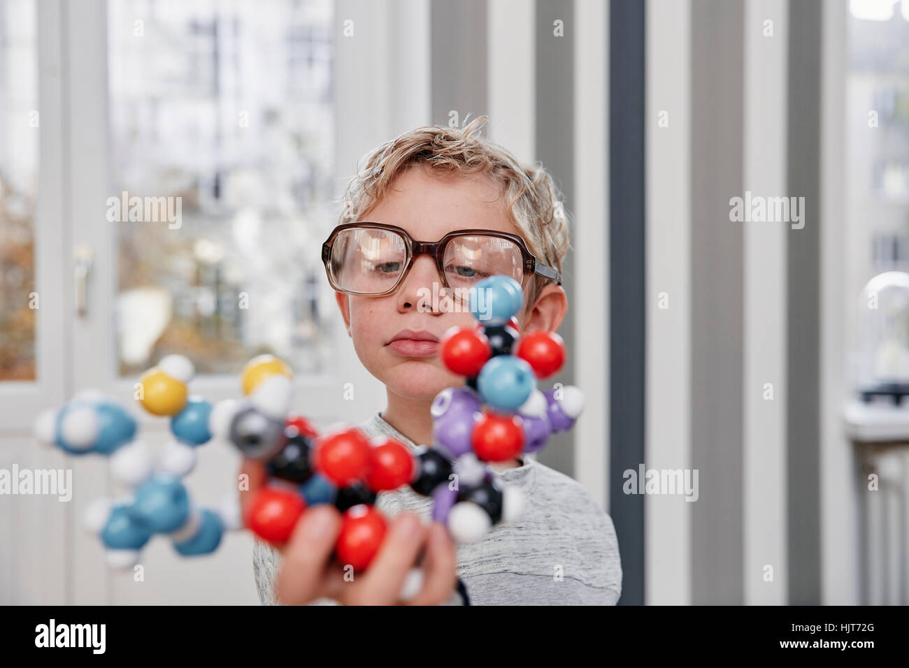 Junge mit überdimensionalen Brille betrachten Molekülmodell Stockfoto