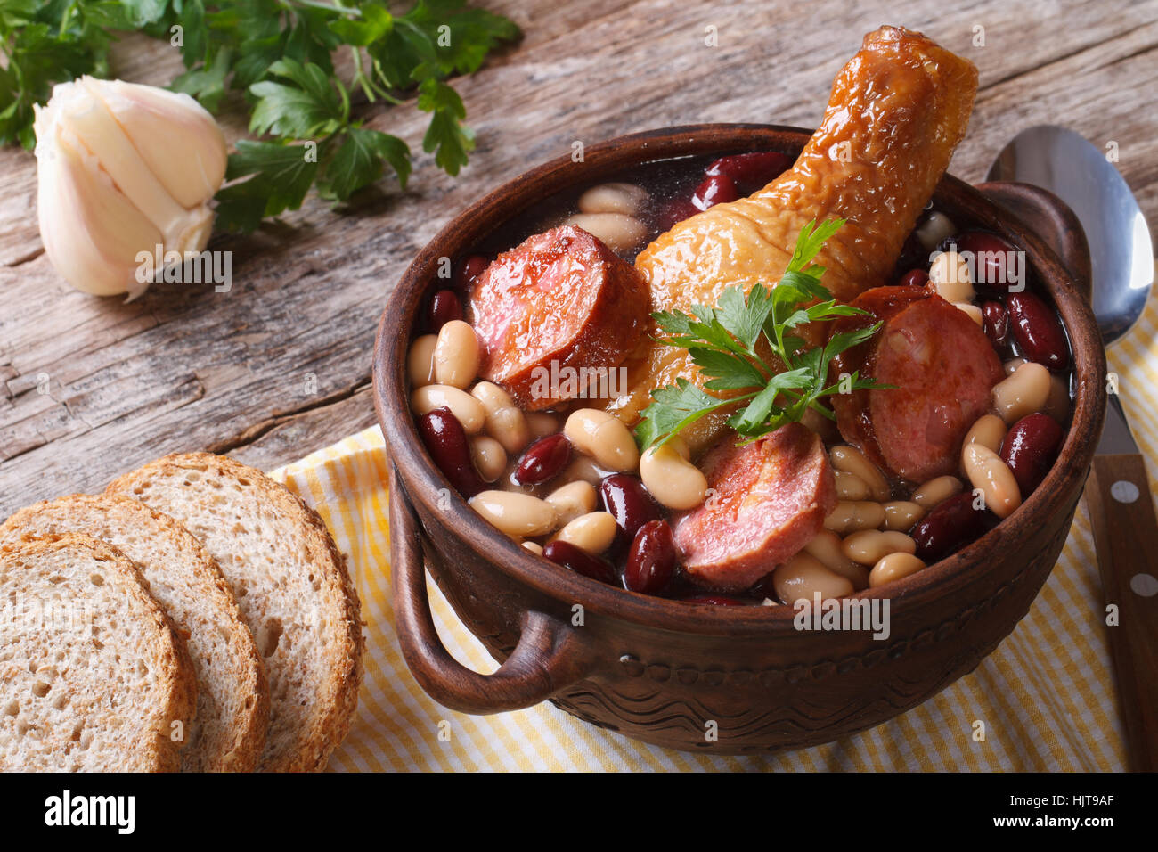 Bohnensuppe mit Hähnchenschenkel und Würstchen in einer Schüssel auf dem Tisch horizontal Stockfoto