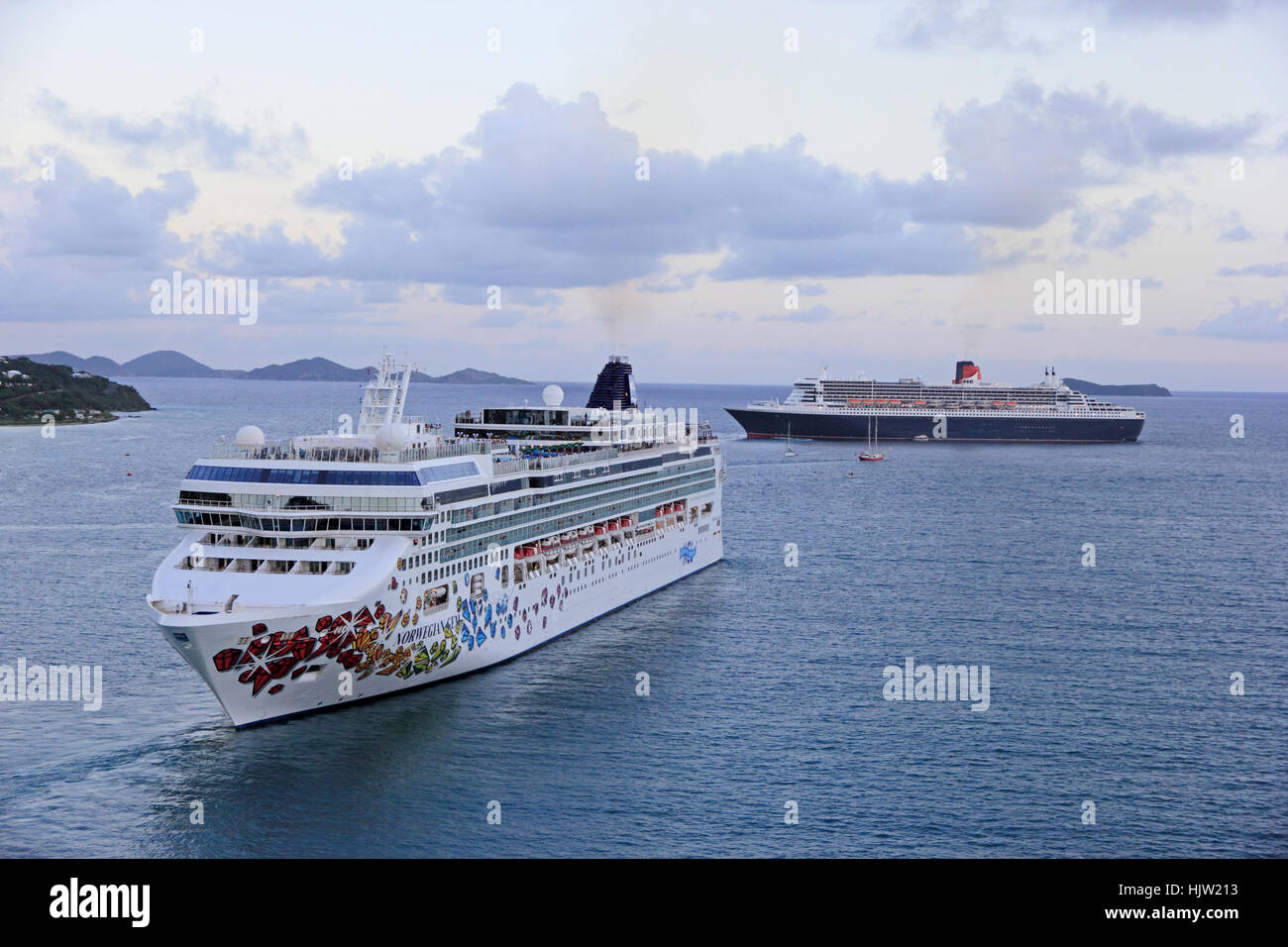 Kreuzfahrt Schiff Norwegian Gem manövrieren vor Abend Abfahrt von Tortola, mit Cunard Liner Queen Victoria im Hintergrund Stockfoto