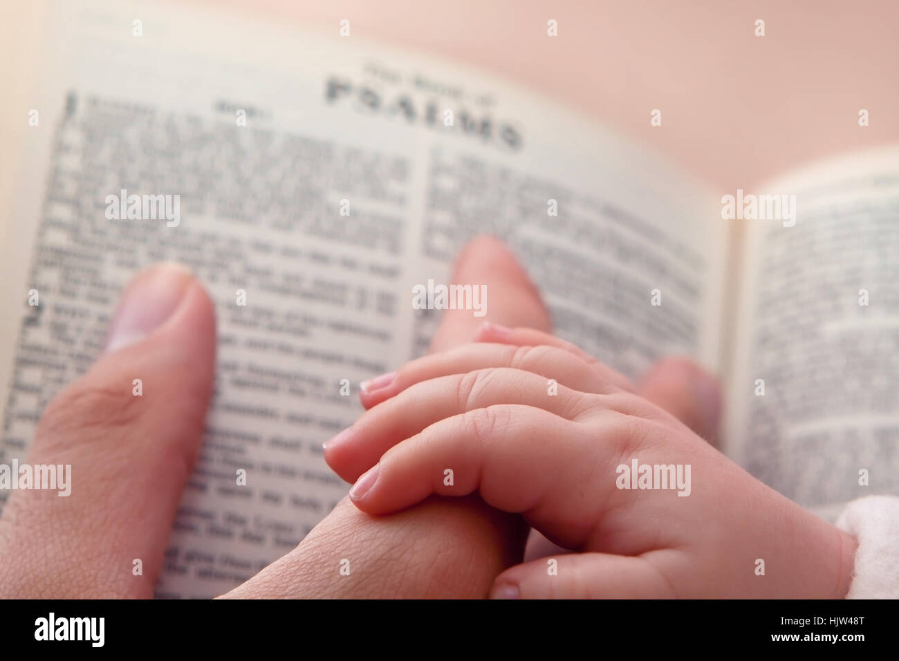 Baby halten Vater Finger, wie er auf Psalmen Vers zeigt Stockfoto