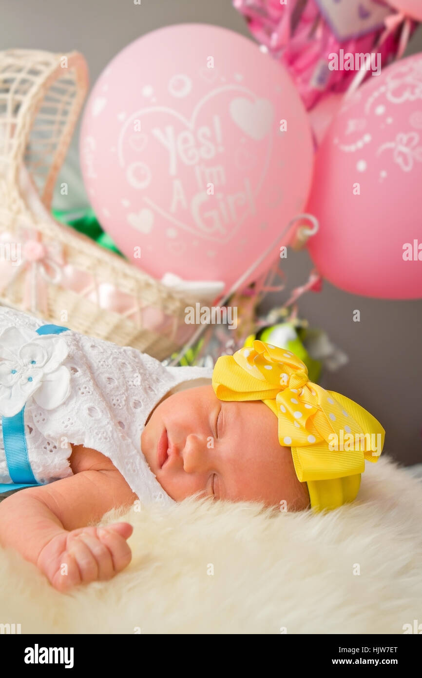 Neugeborene Mädchen schläft mit rosa Ballons Stockfoto