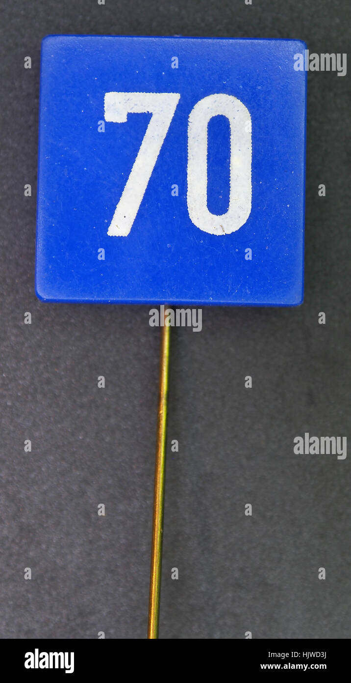 Verkeersbord 70kmu, ein niederländisches Verkehrszeichen, das die Geschwindigkeitsbegrenzung von 70 km/h repräsentiert, wird als Sammlerstück verwendet, um das Bewusstsein für die Straßenverkehrssicherheit zu fördern. Der Pin diente wahrscheinlich als Teil einer Kampagne zur Sensibilisierung der Öffentlichkeit für Straßenverkehrsvorschriften in den Niederlanden, in der die Bemühungen des frühen 20. Jahrhunderts gezeigt wurden, funktionale und Werbeartikel im Verkehrsmanagement zu kombinieren. Stockfoto