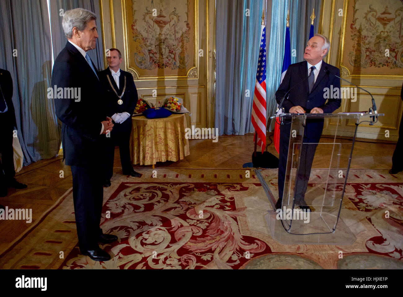 US-Außenminister John Kerry hört, wie der französische Außenminister Jean-Marc Ayrault bereitet ihm Großoffizier der Ehrenlegion, die zweit-höchste Ebene des französischen Award, vergeben, während einer Zeremonie am 10. Dezember 2016, des Quai d ' Orsay - des französischen Außenministeriums - in Paris, Frankreich. Stockfoto