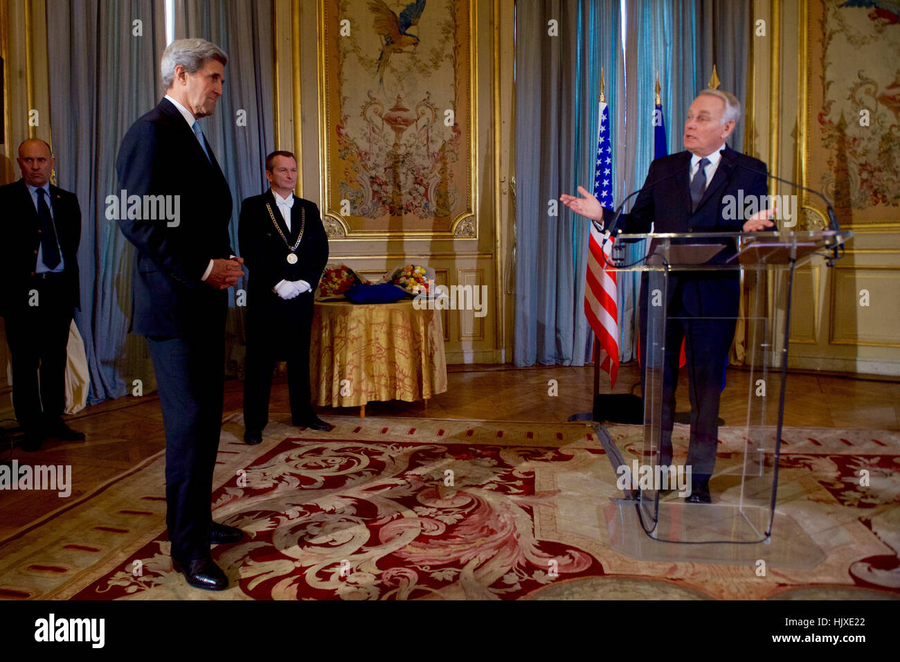 US-Außenminister John Kerry hört, wie der französische Außenminister Jean-Marc Ayrault bereitet ihm Großoffizier der Ehrenlegion, die zweit-höchste Ebene des französischen Award, vergeben, während einer Zeremonie am 10. Dezember 2016, des Quai d ' Orsay - des französischen Außenministeriums - in Paris, Frankreich. Stockfoto