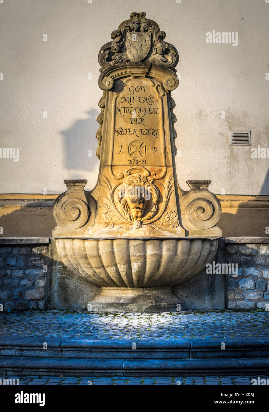 Historischer Brunnen mit Ornamenten und Löwenkopf Stockfoto