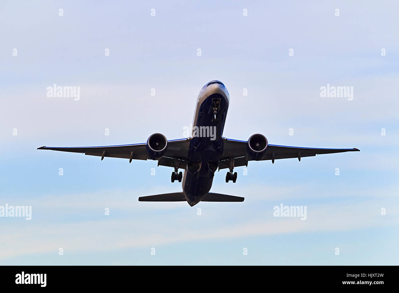 Moderne Jet-Flugzeug abheben vom Flughafen mit Chassis noch gegen hellen Himmel mit seinem unteren Teil in der Luft. Stockfoto