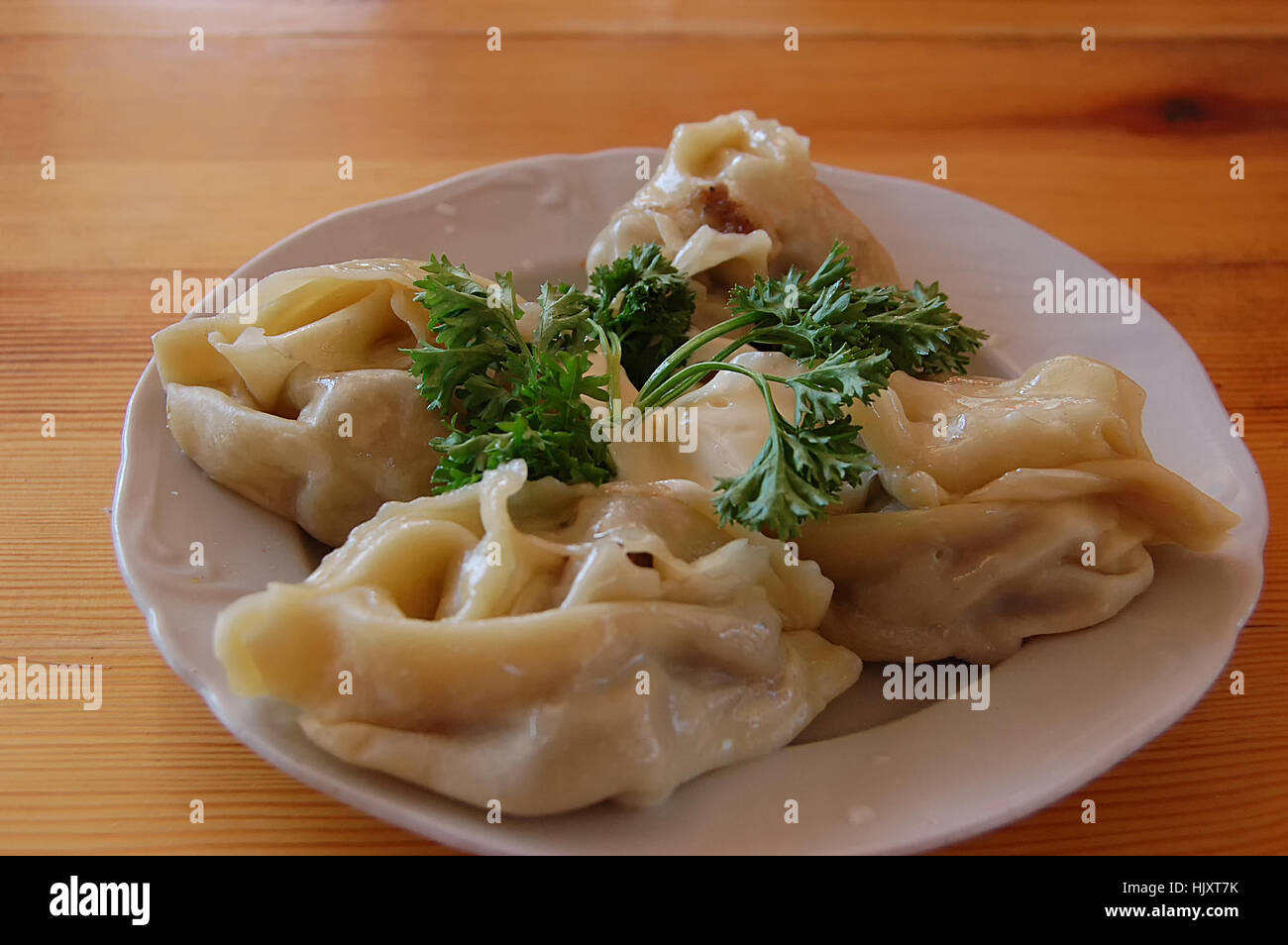 Fleisch-Manti mit Petersilie auf einem Tisch Stockfoto