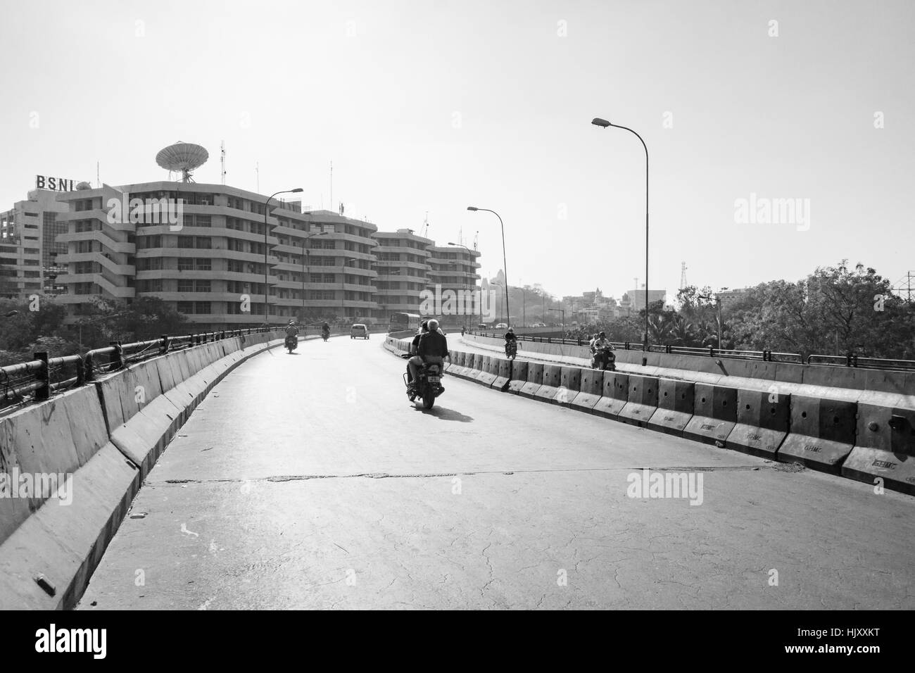 Motorradfahrer auf einer fast leeren Straße in Hyderabad, Indien Stockfoto