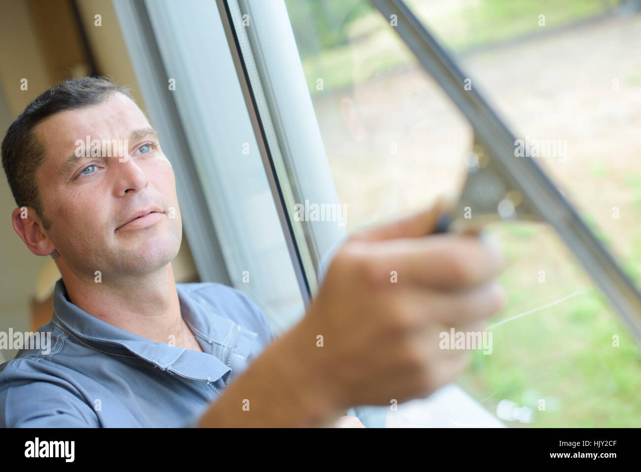 Mann, die Reinigung von Fenstern mit Rakel Stockfoto