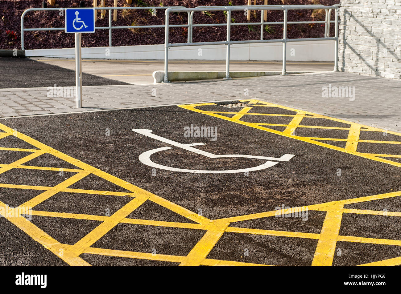 Ein Behindertenparkplatz und Zeichen auf einem Parkplatz mit Textfreiraum. Stockfoto