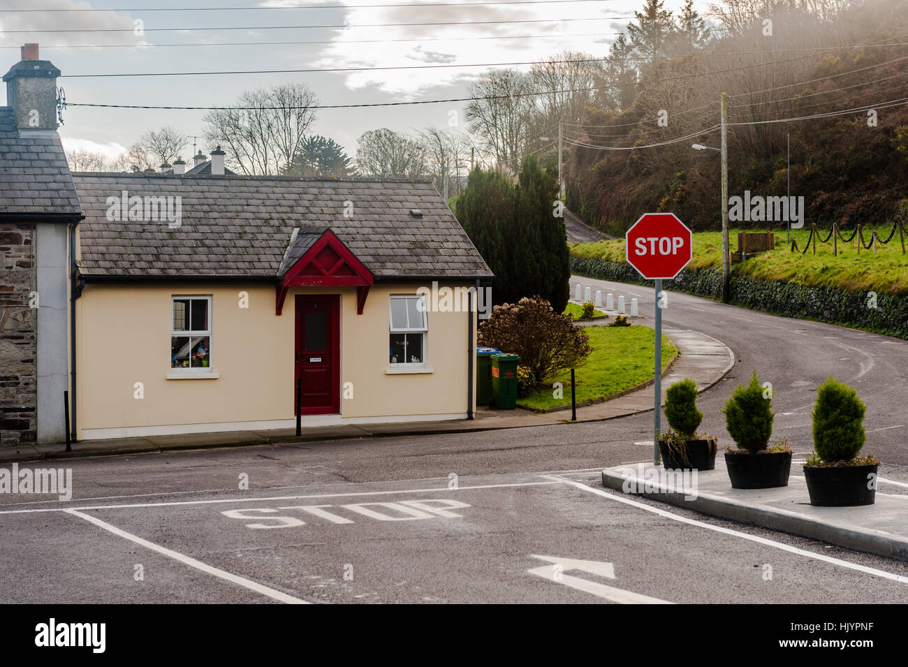 Eine malerische Bungalow an einer Straßenkreuzung mit einem Stop-Schild und textfreiraum in West Cork, Irland. Stockfoto
